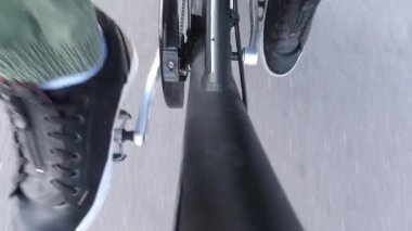Bisikletçi pedalları çeviriyor ve pedal güç yardımıyla elektrikli bisiklete biniyor. E bisiklet teçhizatı yukarıdan yaklaşıyor. Egzersiz ve sağlıklı bir yaşam tarzı. Şehirde hareketlilik.