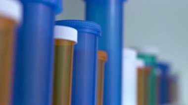 Farklı ilaç şişeleri makro yakın çekim. Eczane masasının yanında kayıyor. Modern ilaç ve eczane endüstrisi konsepti. Coronavirus COVID fikrini önlemek veya tedavi etmek için araştırma ve geliştirme ilaçları.