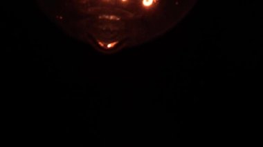 Edison ampulü yavaş yavaş odak ve detaylarla ortaya çıkar. Vintage filament ampulün altında kayarak alttaki makro görüntüyü bokeh efektiyle parlıyor ve parlatıyor. 4K.