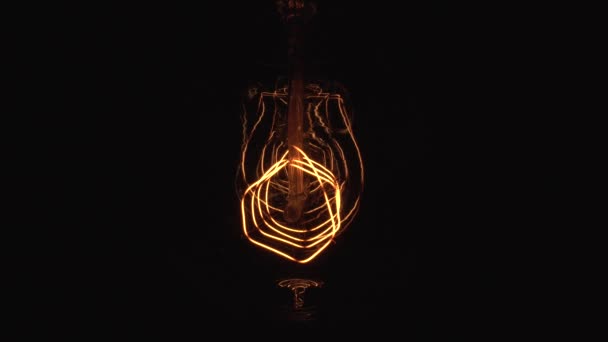 Flickering Tungsten light bulb lamp on black background. Periodic dimming of vintage Edison light bulbs in darkness. Electricity problem or horror movie concept. — 비디오