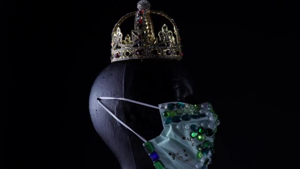 Κούκλα κεφάλι φορώντας σχεδιαστής ιατρική αστική πολυτέλεια στολίδι προστατευτική μάσκα και χρυσό στέμμα. Μόδα δημιουργική τάση σχεδιασμού κατά τη διάρκεια της νόσου του ιού, COVID 19 coronavirus και μάσκα έννοια έλλειψη. — Αρχείο Βίντεο
