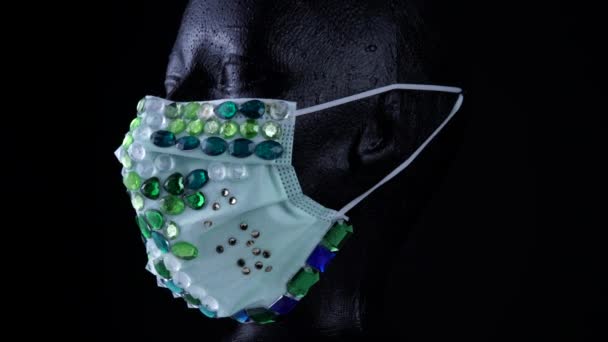 Maniquí con máscara facial de diamantes de lujo de moda urbana médica. Concepto de diseñador artístico durante la enfermedad vírica COVID 19 coronavirus pandemia autoaislamiento. Accesorio de piedras preciosas rizadas de lujo . — Vídeo de stock