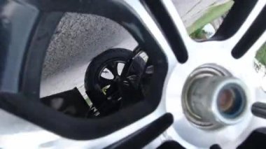 Elektronik motosiklet ya da hareket kabiliyeti olan scooter 'ın alışılmadık görüntüsü. Aracın dönen arka tekerleğine kamera yerleştirilmiş. Arkadan çekilmiş, ekoloji konsepti. E scooter şehir merkezinden geçiyor.