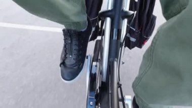 Bisikletçi pedalları çeviriyor ve pedal güç yardımıyla elektrikli bisiklete biniyor. E bisiklet teçhizatı yukarıdan yaklaşıyor. Çerçevedeki pil görüntüsü. Egzersiz ve sağlıklı bir yaşam tarzı..