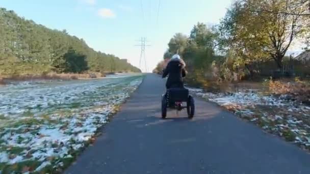 Equitazione e-bike o bicicletta elettrica, girato da dietro, concetto di ecologia. Donna che guida trike elettronico con pedalata assistita. Trasporto alternativo di energia motore. — Video Stock