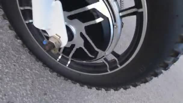 Close up of a front motor wheel spinning under the hood while riding electric scooter. View from the side. Modern alternative transportation, popular mobility option. — Stock Video