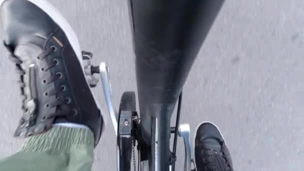 Radfahrer tritt in die Pedale und fährt Elektrofahrrad mit Tretunterstützung. E-Bike Ausrüstung hautnah von oben. Bewegung und gesunder Lebensstil. Aktivitäten in der Stadt. — Stockvideo
