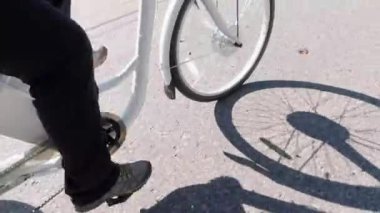 Bisikletçi pedalları çeviriyor ve pedal güç yardımıyla elektrikli bisiklete biniyor. E bisiklet teçhizatı yukarıdan yaklaşıyor. Çerçevedeki pil görüntüsü. Egzersiz ve sağlıklı bir yaşam tarzı..