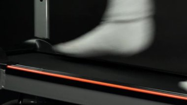 Erkek ayağı koşu bandında yürür, vücudu formda ve formda tutmak için. Kilo kaybederken bir insanın yan bacaklarını kapatın. Spor salonunda kişisel spor yaşam tarzı ve fitness kavramı.