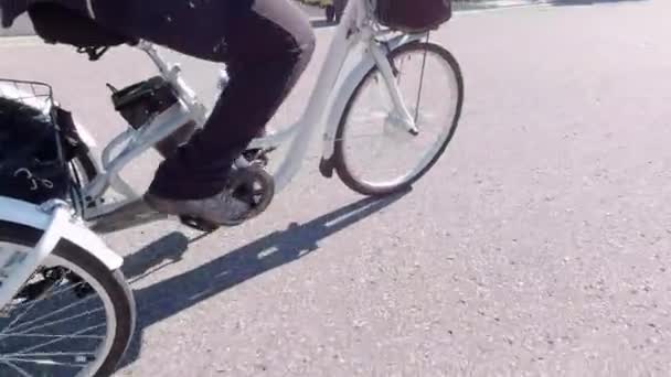 Ciclista montando una bicicleta eléctrica en la zona urbana de la ciudad. Concepto de ecología. Disparo desde el costado . — Vídeo de stock