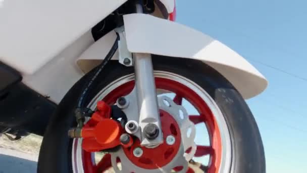 Motorlu scooter kullanırken kaputun altında dönen ön tekerleği kapat. Yukarıdan bak. Modern alternatif ulaşım, popüler hareketlilik seçeneği. — Stok video