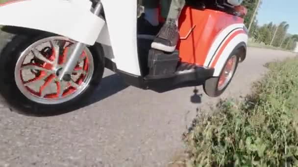 Sluiten van een voorwiel draaien onder de motorkap tijdens het rijden elektrische scooter. Uitzicht vanaf de zijkant. Modern alternatief vervoer, populaire mobiliteit optie. — Stockvideo