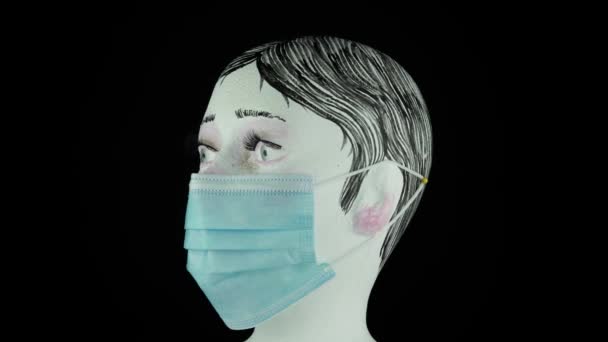 Vrouw hoofd in chirurgische of medische masker, draaien en kijken naar de camera, zwarte achtergrond. Coronavirus pathogeen uitbraak concept. Bacteriën en virusziekten 2019-nCoV bescherming en preventie. 4k. — Stockvideo