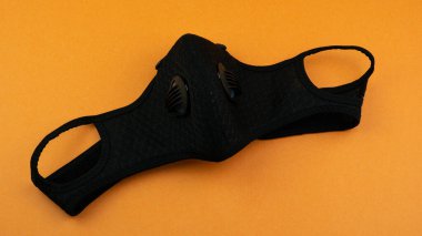 Tıbbi olmayan koruyucu maske değişimi, turuncu arka planda Yeni Normal sosyal konsept. Koronavirüs COVID-19 virüsü ve kentsel hava kirliliğinden korunmak ve korunmak. 