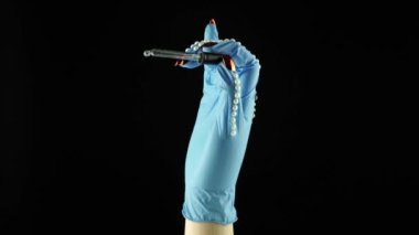 Kadın el ve parmakları aşı pipetini tutuyor. Mavi tıbbi dekore edilmiş eldiven PPE 'yi teslim et. Tek kullanımlık ameliyat eldivenli kadın avucu. COVID 19 Coronavirus için ilaç kavramı