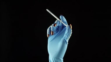 Kadın el ve parmakları aşı şırıngası tutuyor. Mavi tıbbi dekore edilmiş eldiven PPE 'yi teslim et. Tek kullanımlık ameliyat eldivenli kadın avucu. COVID 19 Coronavirus için ilaç kavramı