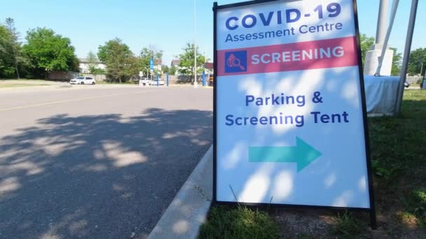 Covid-19 Assessment Centre Screening Parking and Screening Tent sign near hospital in the city. Coronavirus test for workers due pandemic. The fight with virus and second wave control. — Stock Video