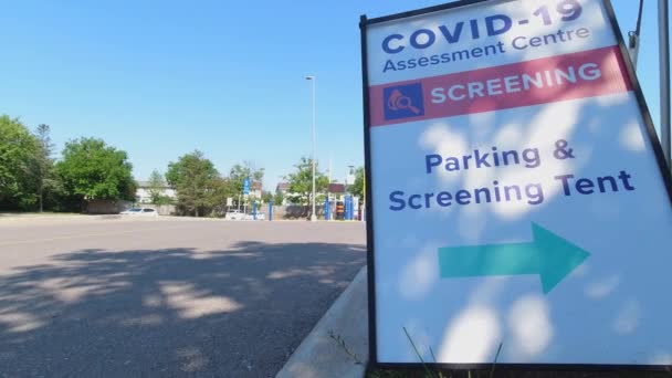 多伦多，安大略，加拿大。2020年8月，Covid-19评估中心（英语：Covid-19 Assessment Centre）在城市医院附近检查停车和检查帐篷标志。由于流行病而对工人进行的验尸检查。第二波控制. — 图库视频影像