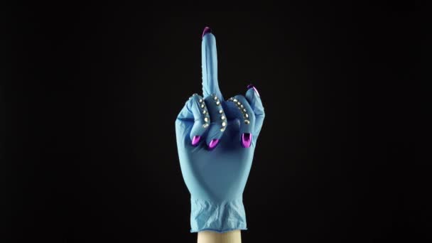 Woman wrist hand and middle finger or fuck you symbol. Hand in the blue medical decorated glove PPE. Female palm in disposable surgical protective glove. Concept victory fight of COVID 19 coronavirus — Stok video