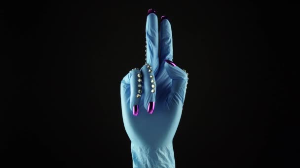 Mulher pulso mão e dedo apontar para cima símbolo. Mão na luva decorada médica azul EPI. Palma feminina em luva protetora cirúrgica descartável. Conceito de mostrar a direção. — Vídeo de Stock