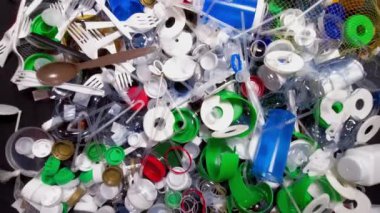 Tek kullanımlık plastik çöp. Geri dönüşümsüz plastik atıkla çöp sahalarının aşırı kirlenmesine dikkat çekmek. Masanın üzerinde biyolojik olarak çözünemeyen zehirli bir çöp var. Çevre sorunları.