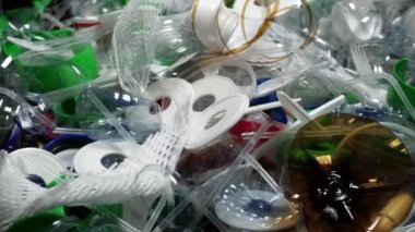 Plastik şişe parçaları, bardaklar, mantarlar, pipetler, su ve şampuan şişeleri, krem ambalajlar ve masaya atılan diğer bir kerelik çöpler. Çevre kirliliği, geri dönüşüm, atık yönetimi sorunu.