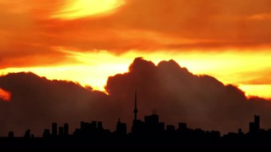 Kuzey Amerika silueti silueti gün batımı zamanı. Şehir kuleleri ve şehir manzarası, güneş batarken renkli sıcak bulutlarla doluyor. Amerikan şehir merkezindeki sanat kolajının üzerine güneş battı. Sis 'in özel efektleri.