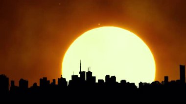 Şehir silueti, sıcak sinematik güneş batımı, şehir merkezi, büyük güneş batımı ışığı olan şehir merkezi. Sanatsal efektler parlayan hava sisi. Destansı sıcak yaz gökyüzü yağmurdan sonra. Isı dalgası uyarısı.
