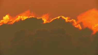 Büyük, destansı, parlak güneş akşamları bulutlar salıyor. Canlı renk arkaplanı zaman aşımı. Sinema yağmurlu yaz gökyüzü. Parıldayan ısı dalgası etkisi.