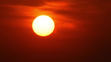 Kırmızı sarı ve turuncu gökyüzü zaman dilimli sinematik güneş batıyor. Sarı güneş destansı altın saat hızında batıyor. Yuvarlak güneş diskinin yakın görüntüsü. Sıcak yaz atmosferi sıcak hava dalgasında.