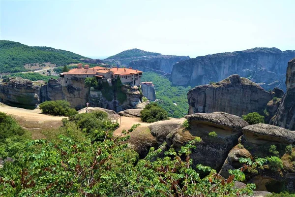 Meteora Land in the Sky: Great ancient city of Meteora in Greece. Trees, vintage houses, blue sky and white clouds.