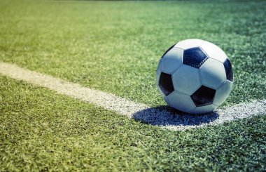 Çimenlerin üzerinde eski futbol topu