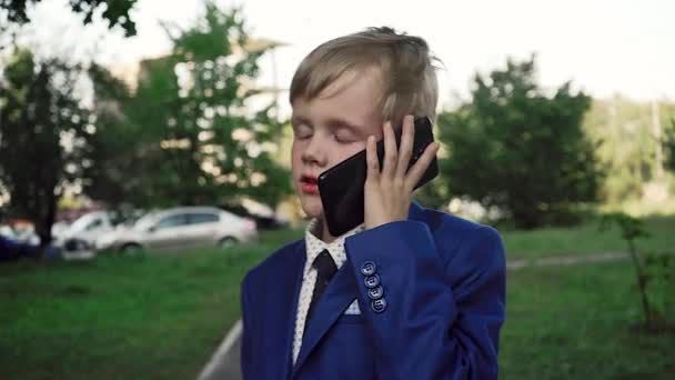 Mały Chłopiec Poważną Twarz Garniturze Jest Ulicą Rozmawia Przez Telefon — Wideo stockowe