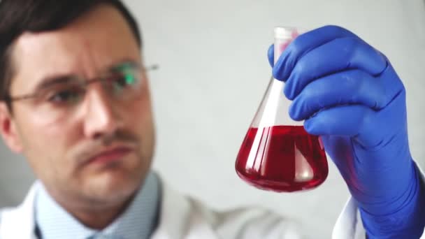 Medico Mescola Liquido Rosso Nel Pallone Concentrarsi Sul Tubo — Video Stock