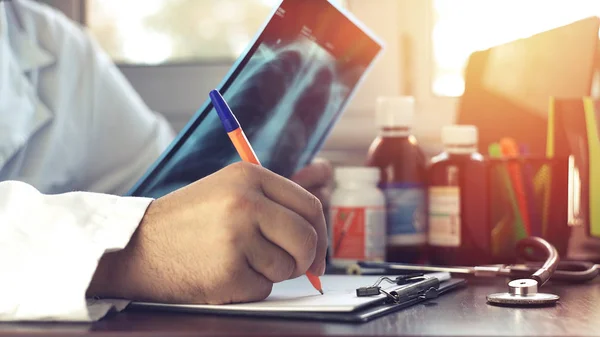 Doktor MRI tarama akciğerlerinin incelenmesi ve bir sonuç yazma.