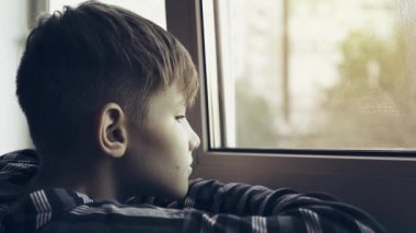 Genç üzgün ve yalnız pencereden bakıyor. Genç depresyona girdi