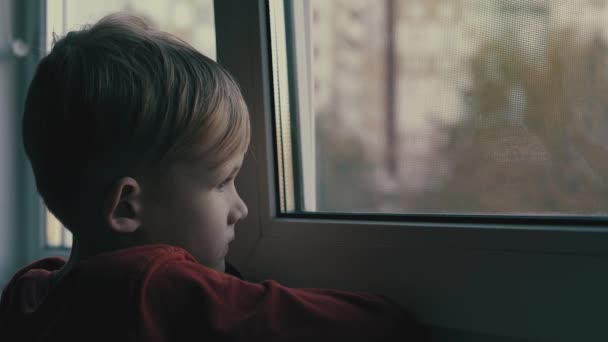 dítě, smutný a osamělý, pohledu přes okno. Dítě je v depresi