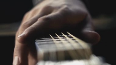 Adam el gitar telleri okşayarak