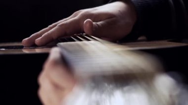 Adam el gitar telleri okşayarak