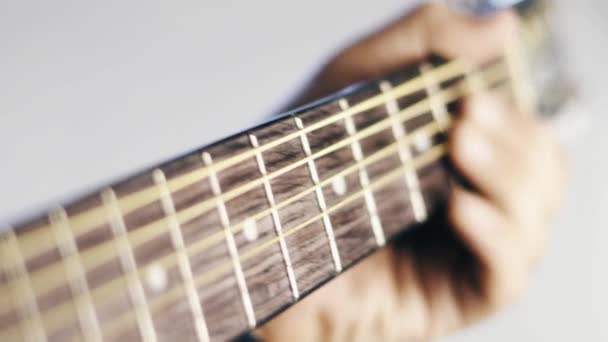 クローズ アップ ホワイト バック グラウンドで再生されているギター — ストック動画