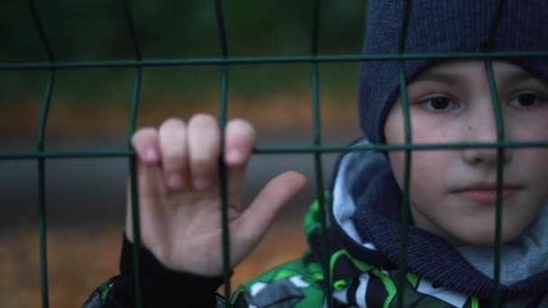 Одинокий Несчастный Несчастный Мальчик Позади Цепляющийся Забор — стоковое видео