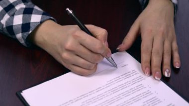 Closeup çekim sayfaları kağıt belge veya bir sözleşme imzalama bir iş kadını. Kağıda sözleşme imza. Tükenmez kalem kağıda sözleşme imza sırasında
