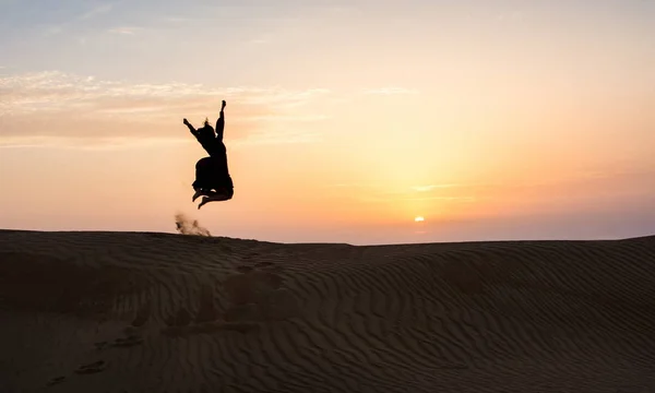 Çölde Günbatımında Atlama Bir Kadın Silüeti — Stok fotoğraf