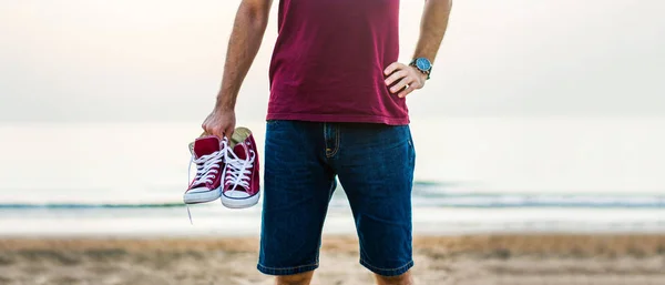 Mann Mit Turnschuhen Der Abenddämmerung Strand — Stockfoto