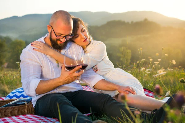ワイングラスの外でピクニック毛布の上に座ってカップル — ストック写真