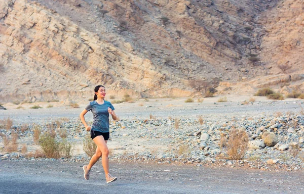 Female running in the desert road, outdoor workout