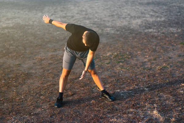 Uomo Che Allunga Prima Dell Allenamento Nel Parco Tramonto — Foto Stock