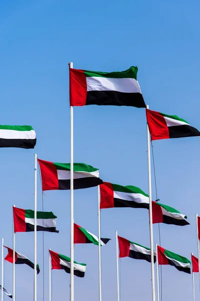 Egyesült Arab Emírségek zászlók a kanyargós a szél ellen, blue sky — Stock Fotó