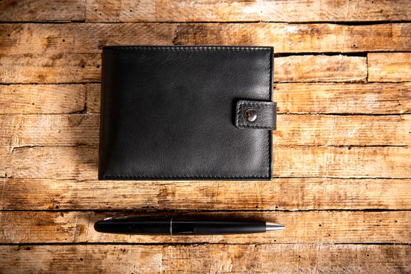 桌子上的黑色皮革钱包和铅笔 — 图库照片