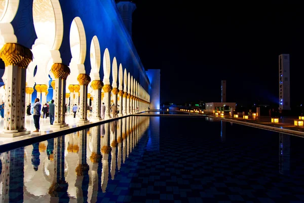 Абу-Даби, Объединенные Арабские Эмираты - 26 января 2018 года: Толпа Шейх Заид Интерьер Большой мечети отражается на поверхности ночью — стоковое фото